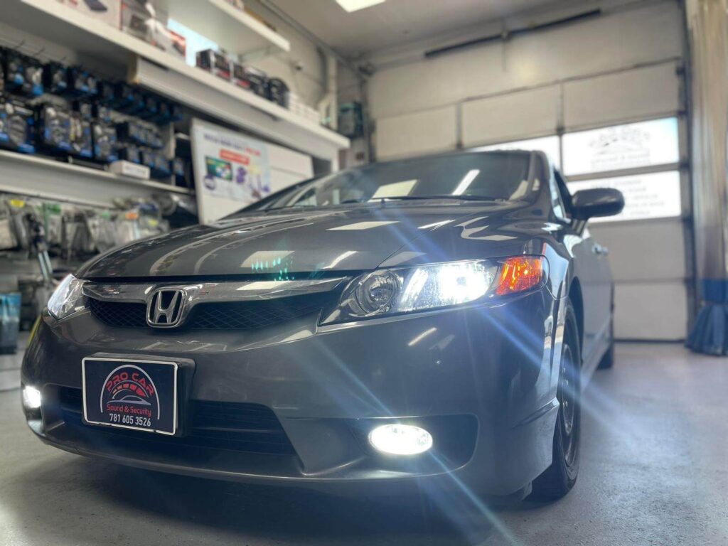 Technician performing headlight installation in Malden, MA