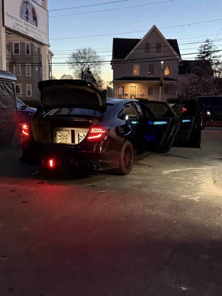Customer's Honda with ambient lighting, doors open outside Pro Car in Malden at dusk