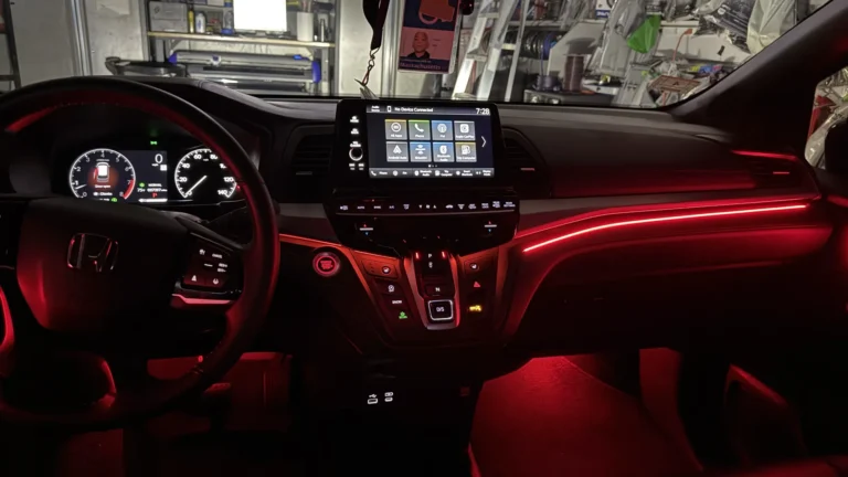 Honda Odyssey dashboard with red ambient lighting and lit footwells