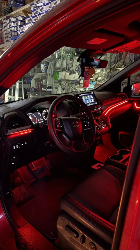 Honda Odyssey cabin with red ambient lighting on the dash and doors