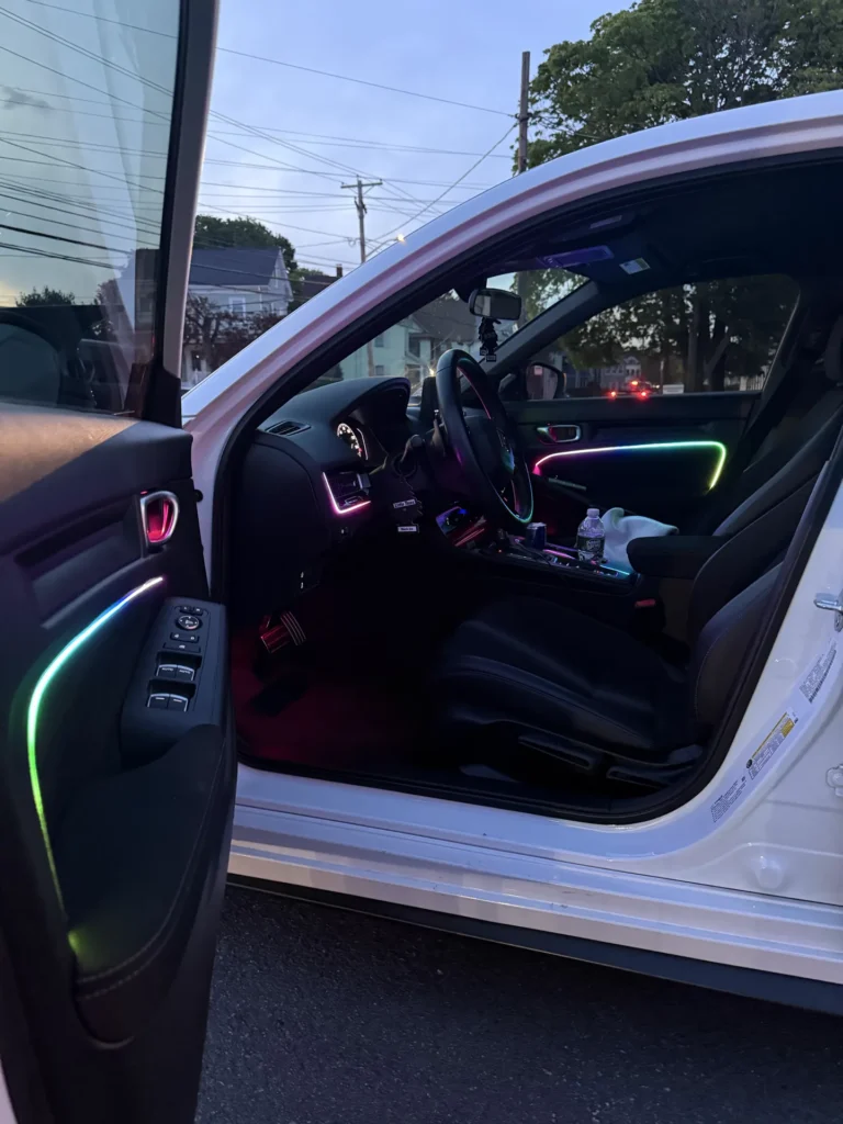 White Honda with multicolor ambient lighting on the doors and dash