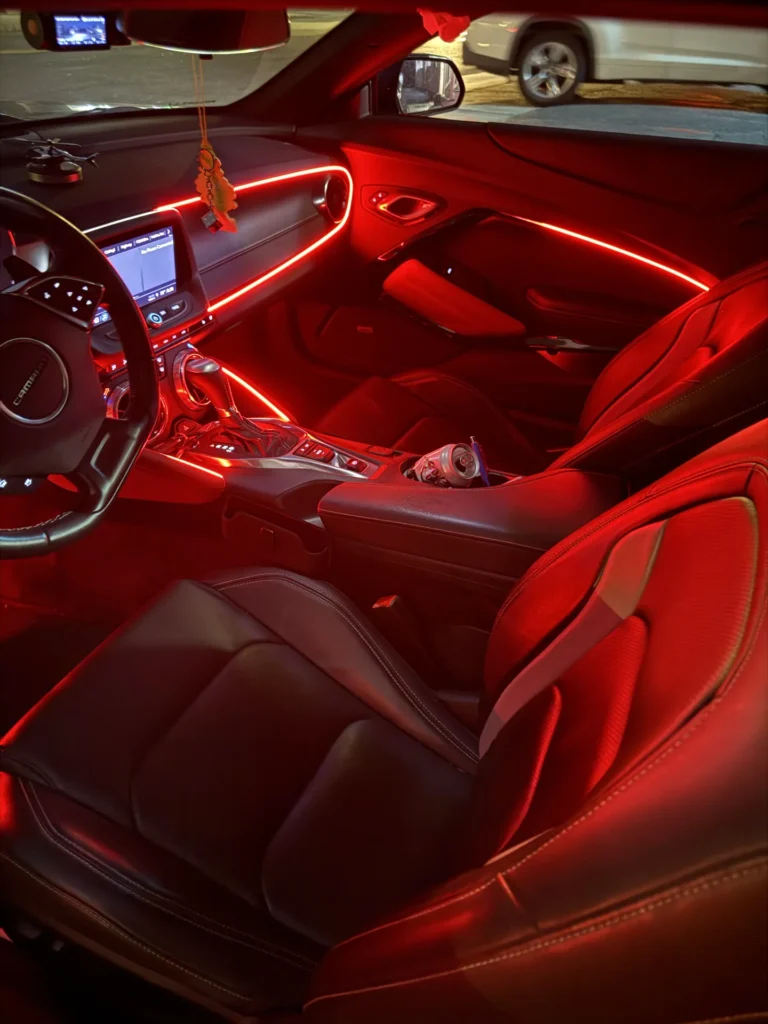 Red ambient light running along the Lexus dash and door at night
