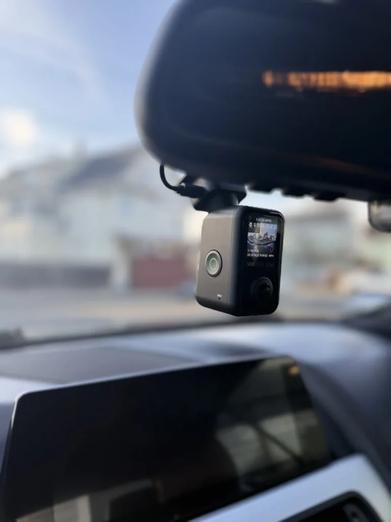 Close-up of a front dash cam installed behind the rearview mirror
