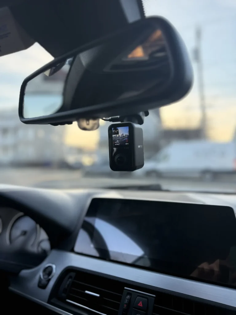 Front dash cam installed under the rearview mirror of a BMW