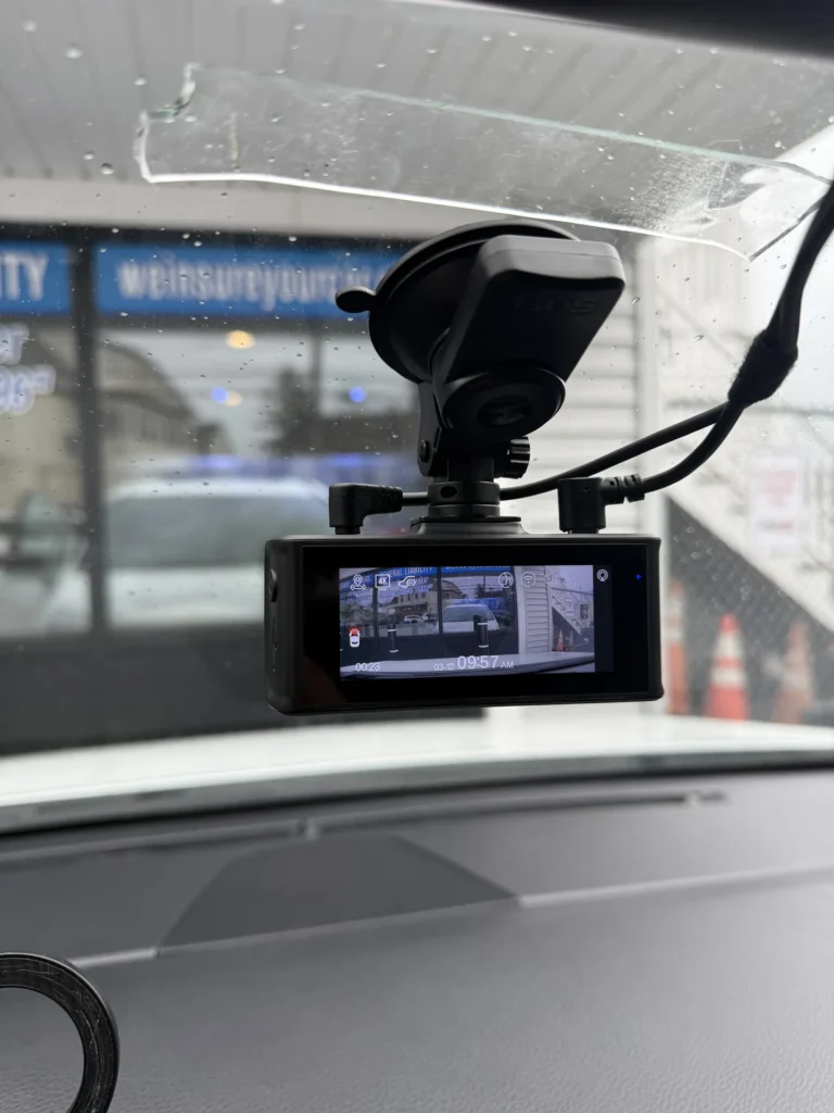 Front dash cam mounted on the windshield with its screen on