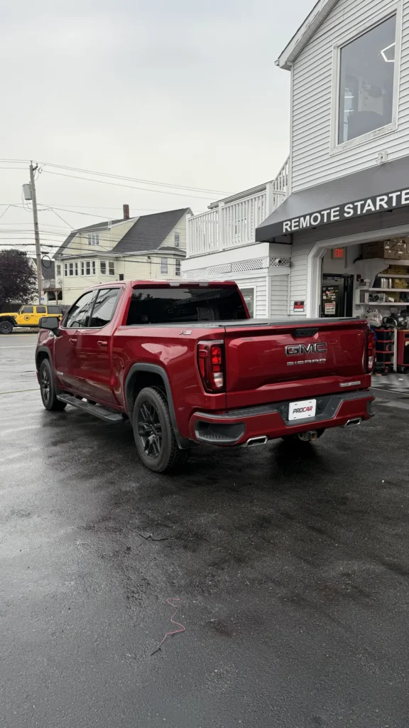 Red GMC Sierra pickup with tinted windows outside Pro Car